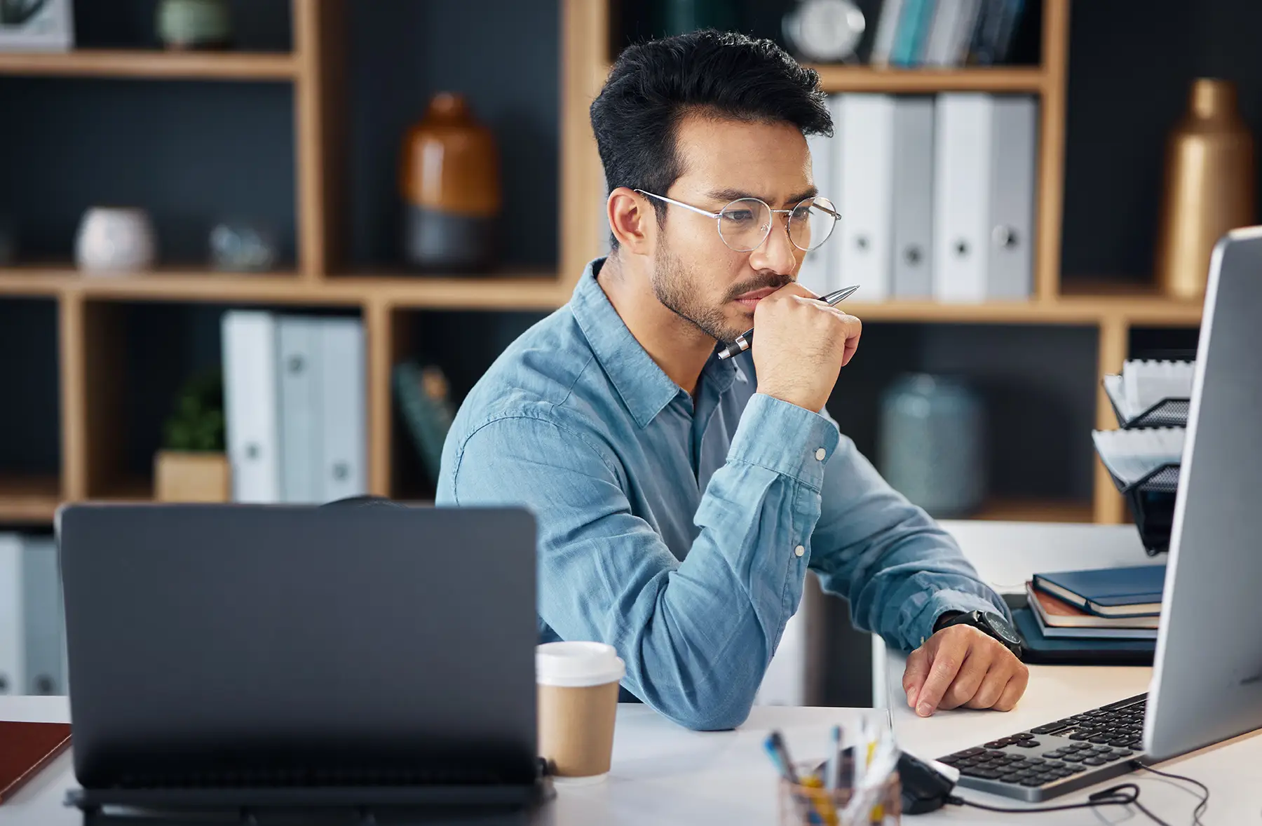 Serious asian man, thinking and computer for digital marketing